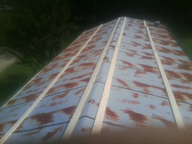 Rusted metal roof panels with new wood purlins before replacement — Storm Damage Roof Repair in Oldhams by Roofing Brothers