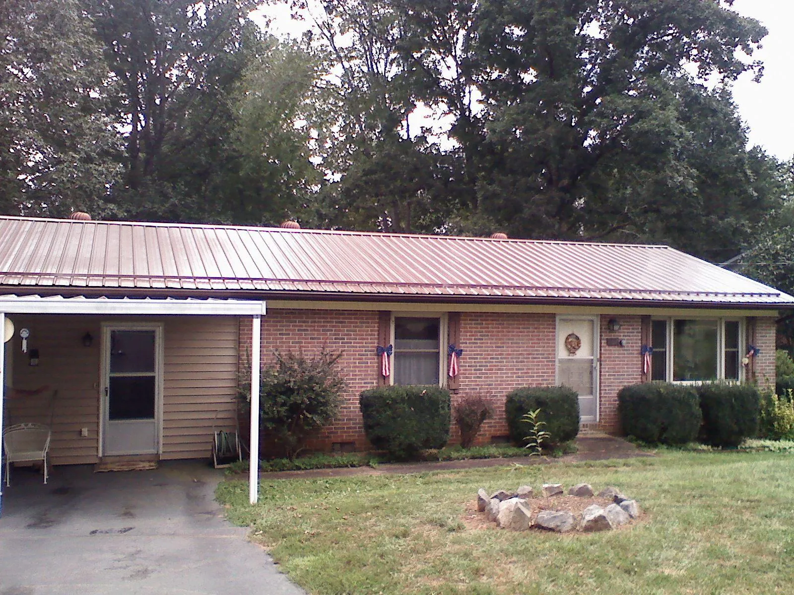Bronze metal roof and carport on a brick ranch home — Roof Repair work by our crew in Oldhams